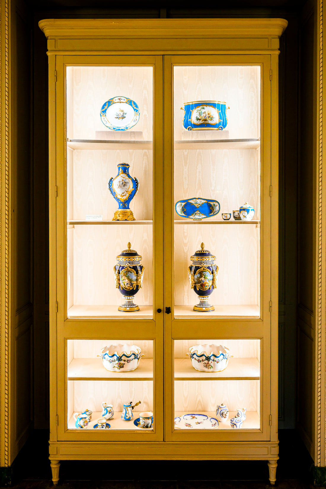 Antique blue-and-white porcelain arranged in an elegant display cabinet