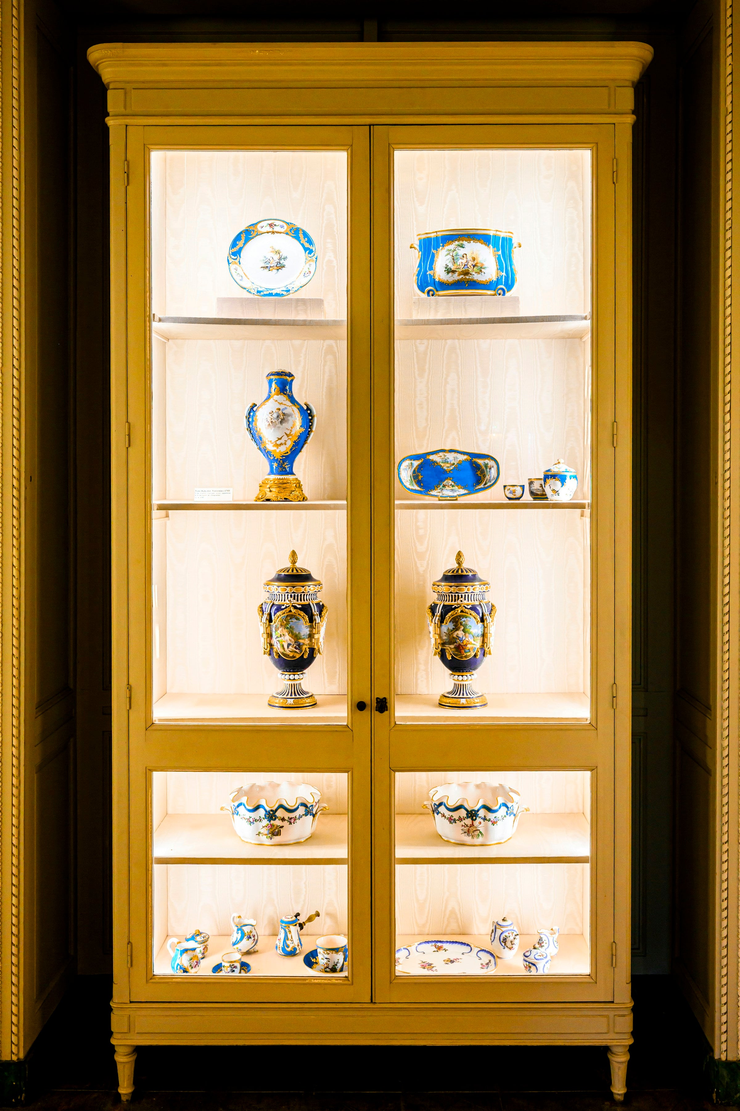Antique blue-and-white porcelain arranged in an elegant display cabinet