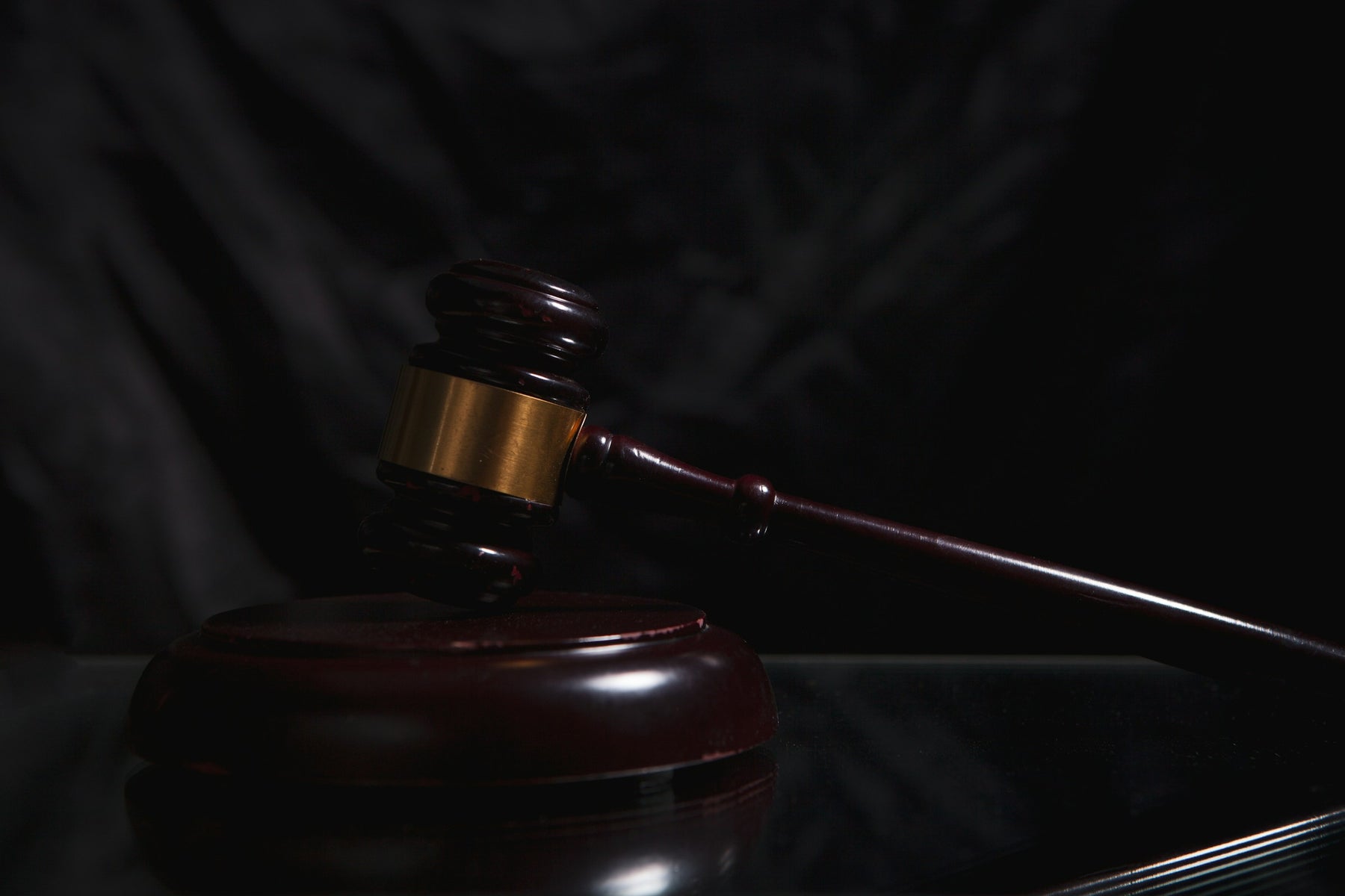 Wooden auction gavel resting on a dark surface